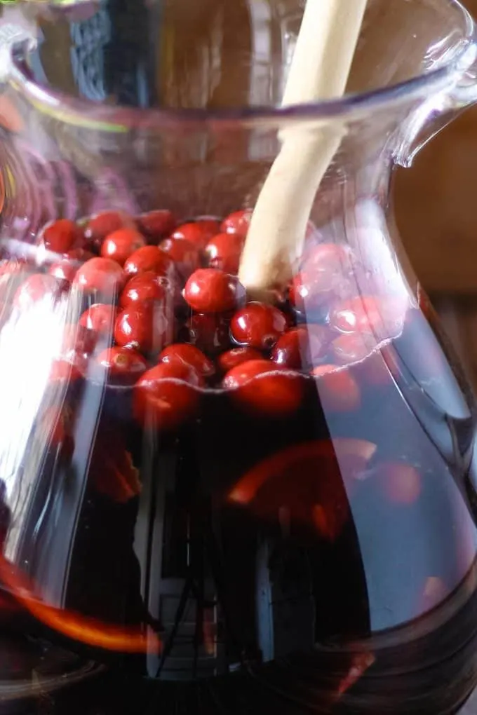 pitcher filled with cranberries and sangria