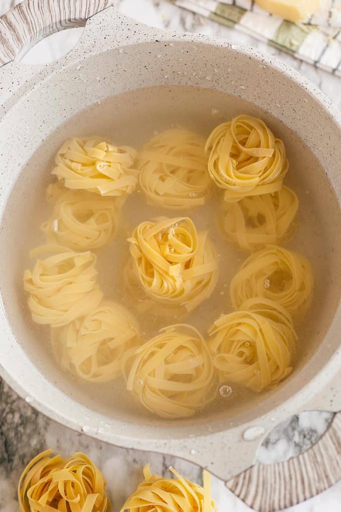 tagliatelle being cooked in a white pot