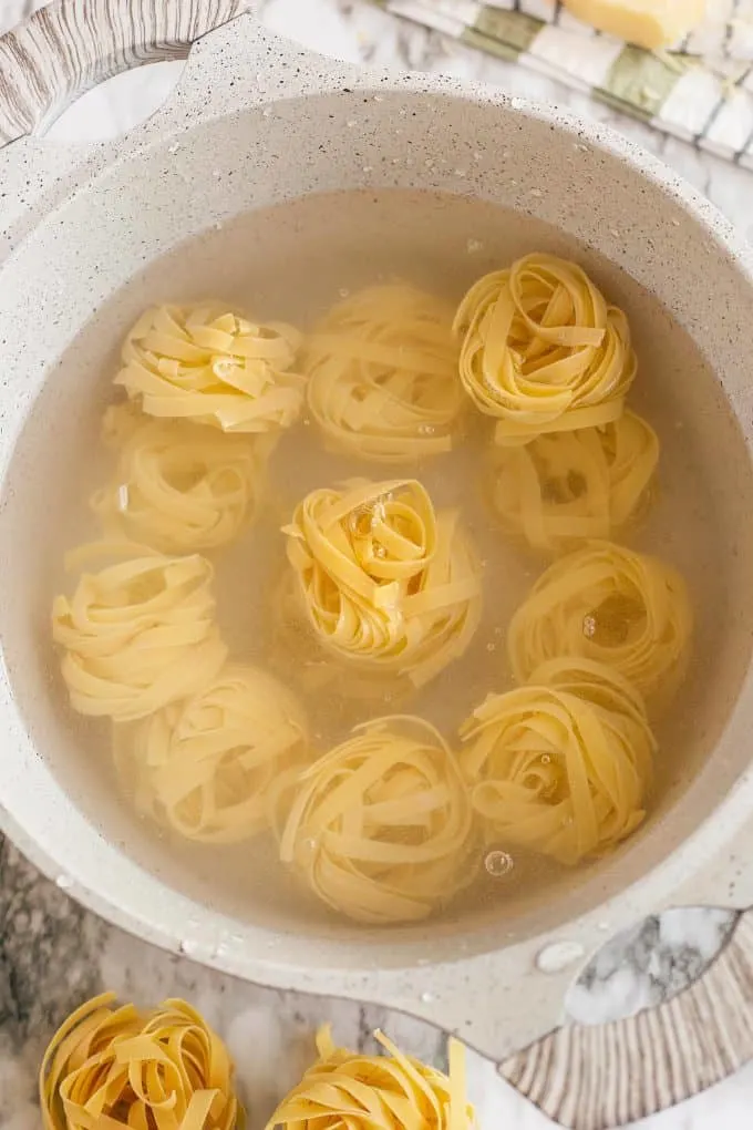 tagliatelle being cooked in a white pot