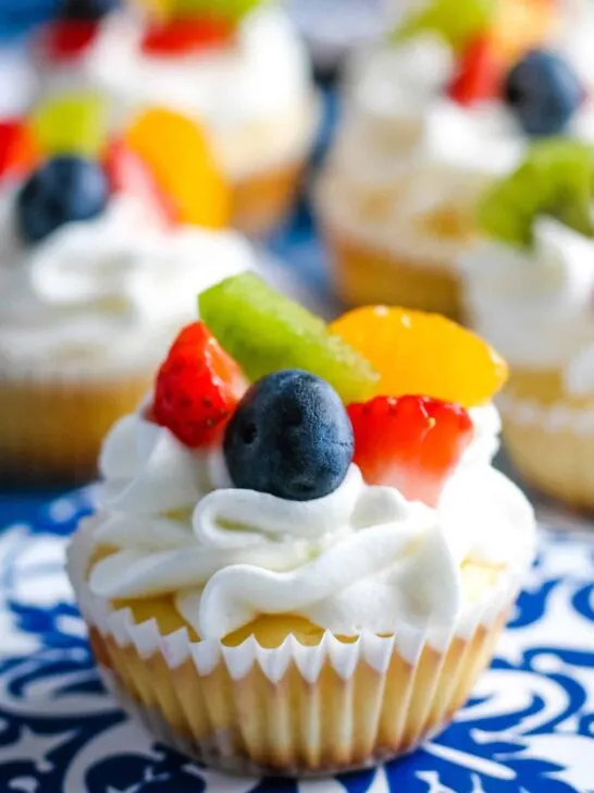 one mini cheesecake topped with fresh fruit and whipped cream