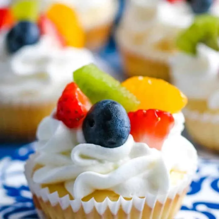 one mini cheesecake topped with fresh fruit and whipped cream