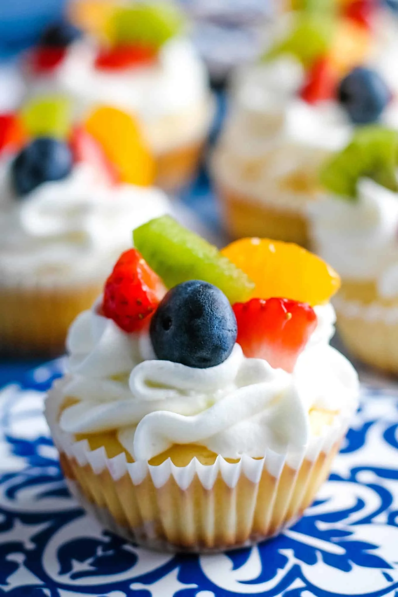 one mini cheesecake topped with fresh fruit and whipped cream