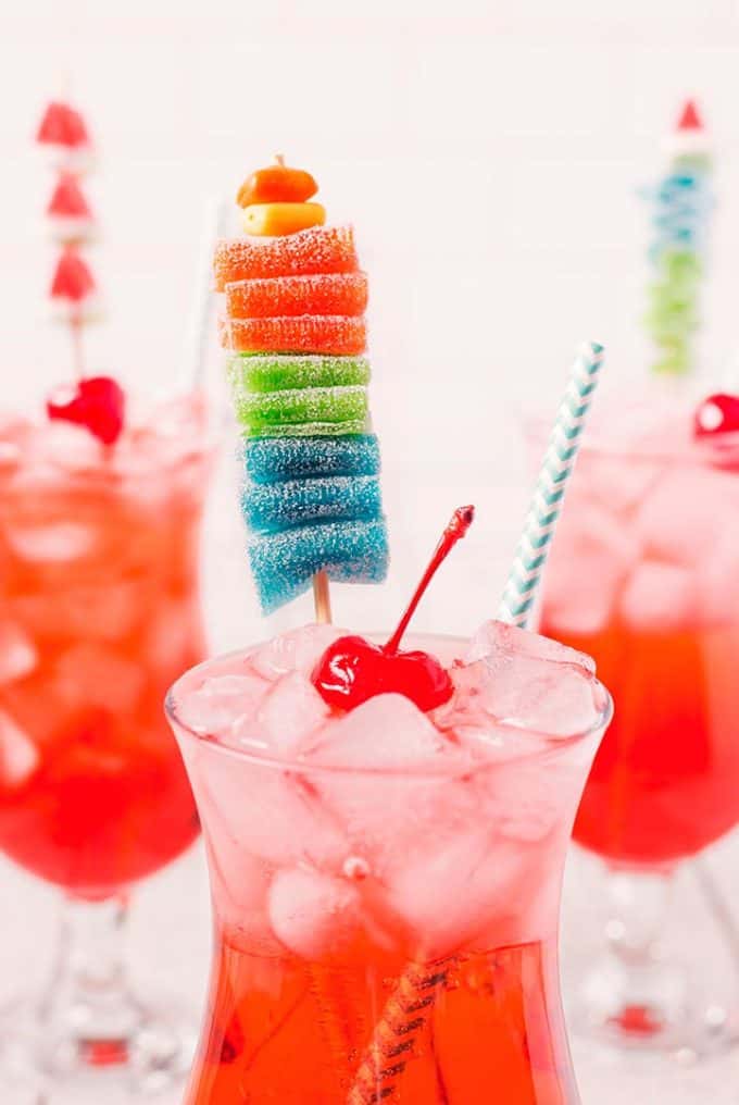 shirley temple in a hurricane glass garnished with a candy kabob and a cherry
