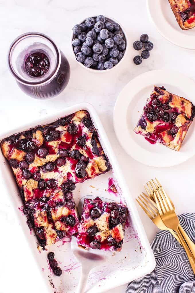 several pieces missing from a white casserole dish and a whole bowl of blueberries