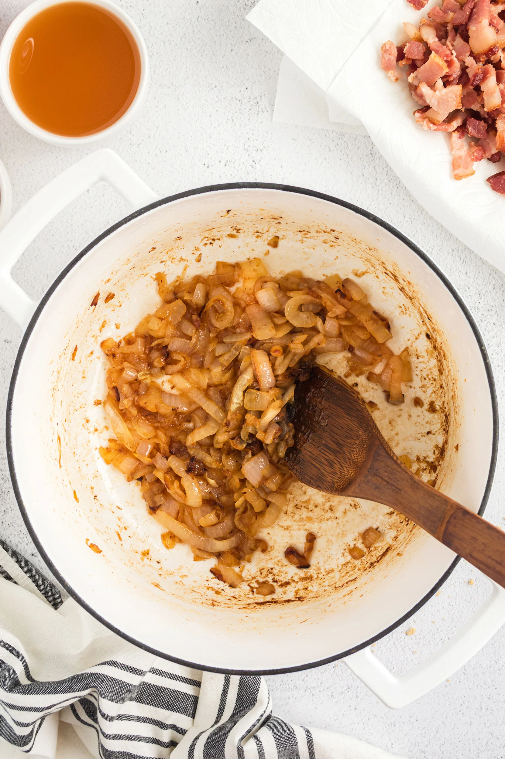 caramelized onions in a dutch oven with a wooden spoon
