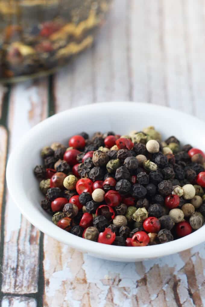 multicolored peppercorns in a small white bowl