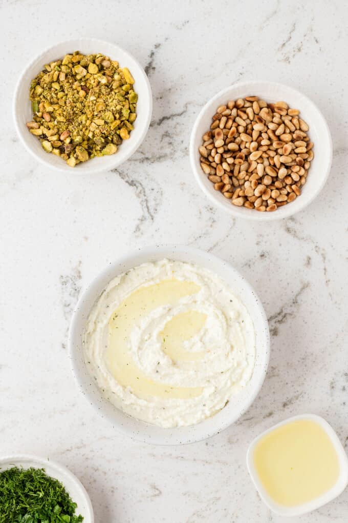 whipped feta dip has been transferred into a serving bowl, waiting to be garnished