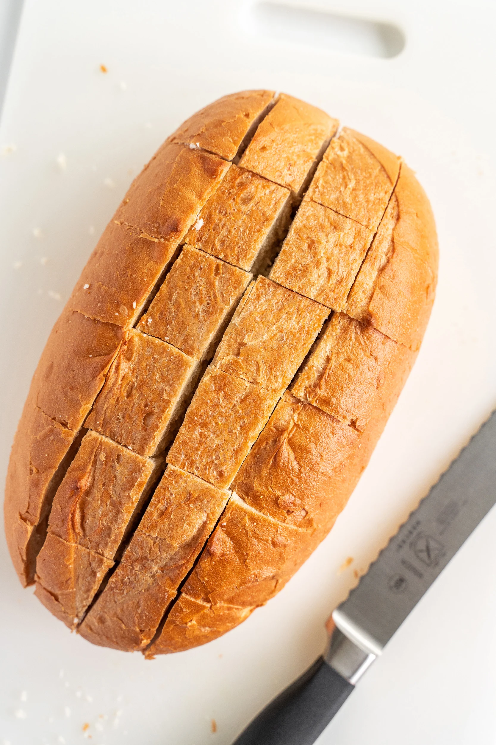 loaf of bread cut into squares with a serrated bread knife