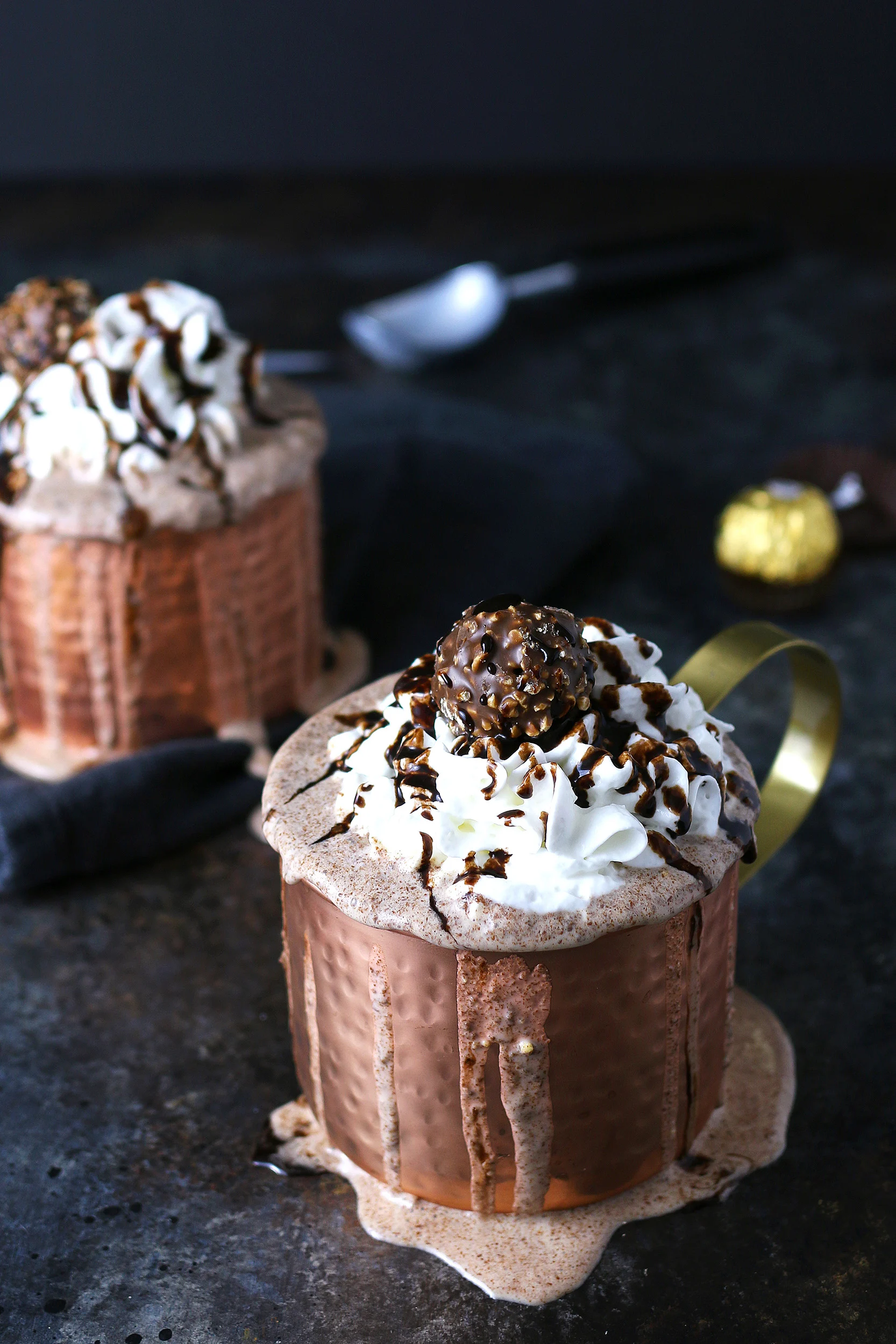 2 milkshakes in a copper mug with Ferrero rocher candies in the background