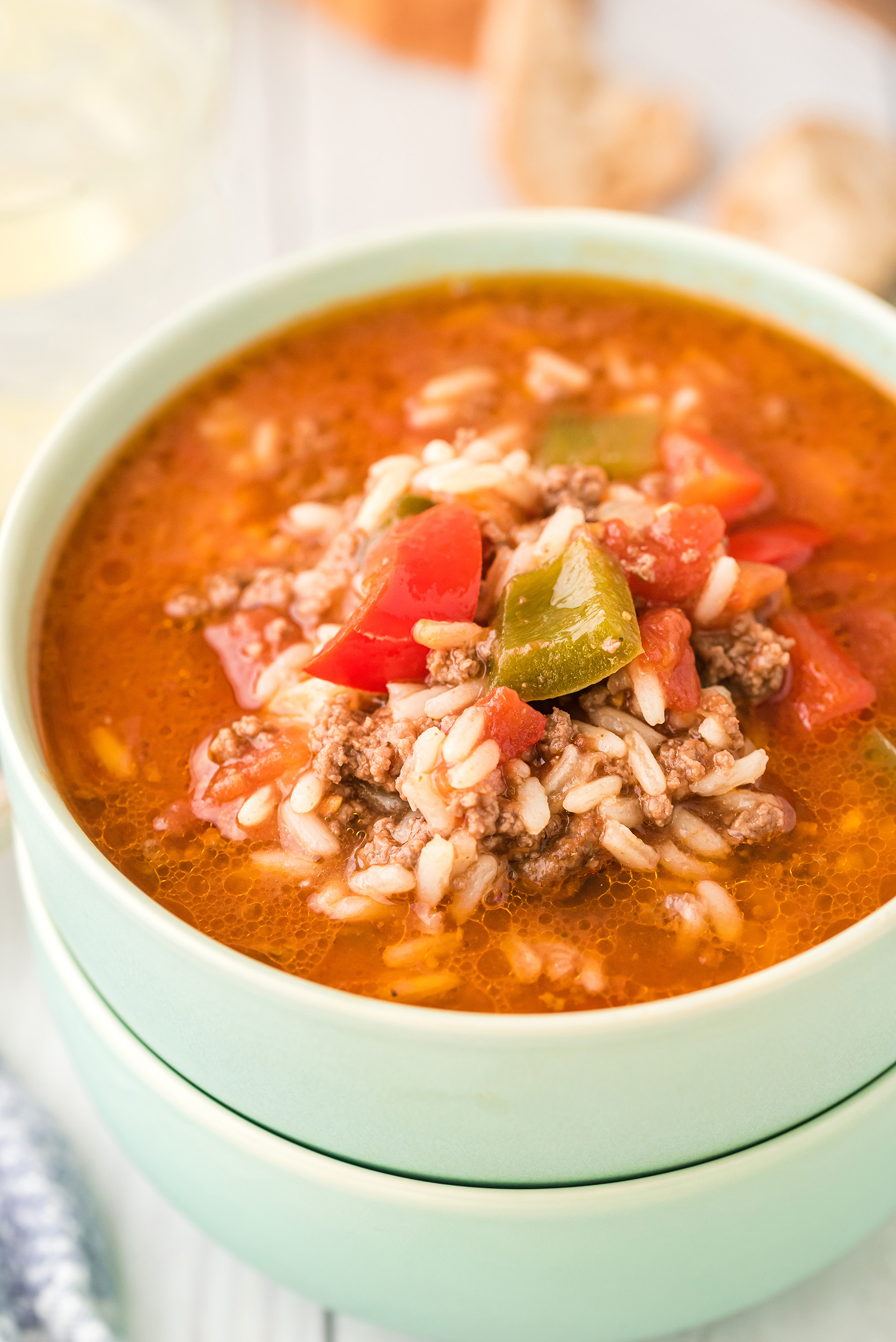 two stacked mint green bowls bowls filled with stuffed pepper soup