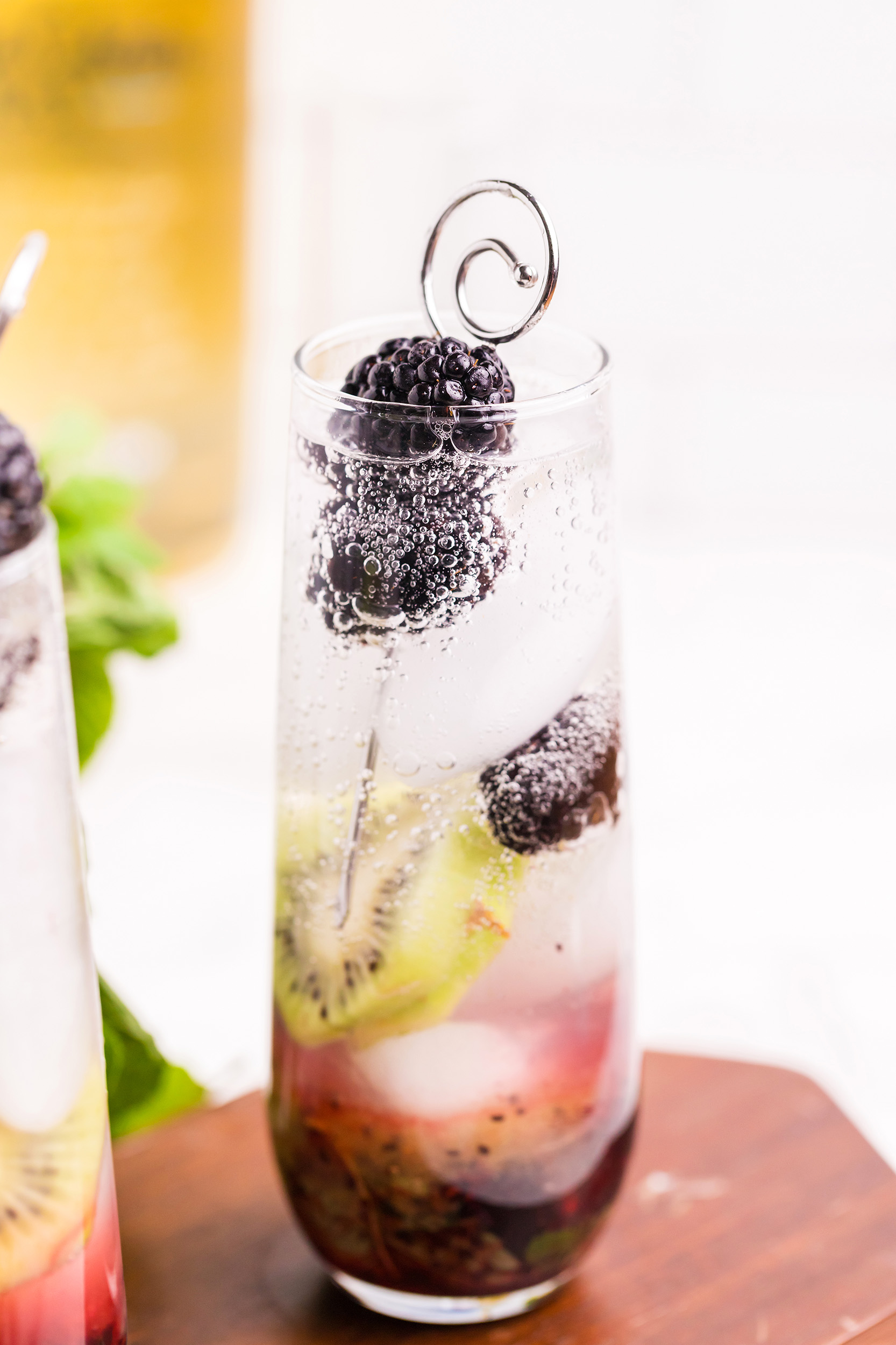 blackberry kiwi mojito garnished with a stick of fresh blackberries