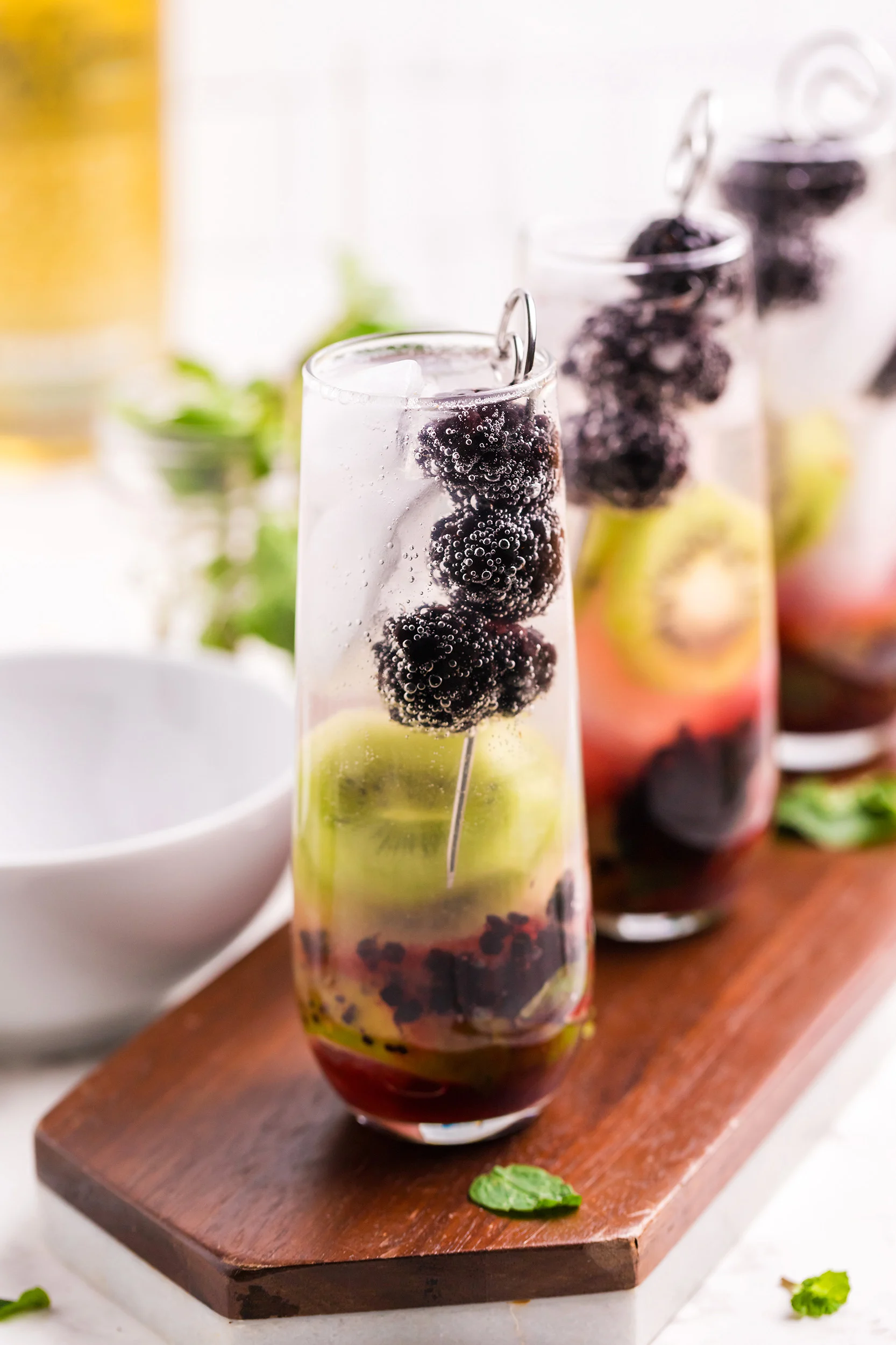 a trio of finished blackberry kiwi mojitos