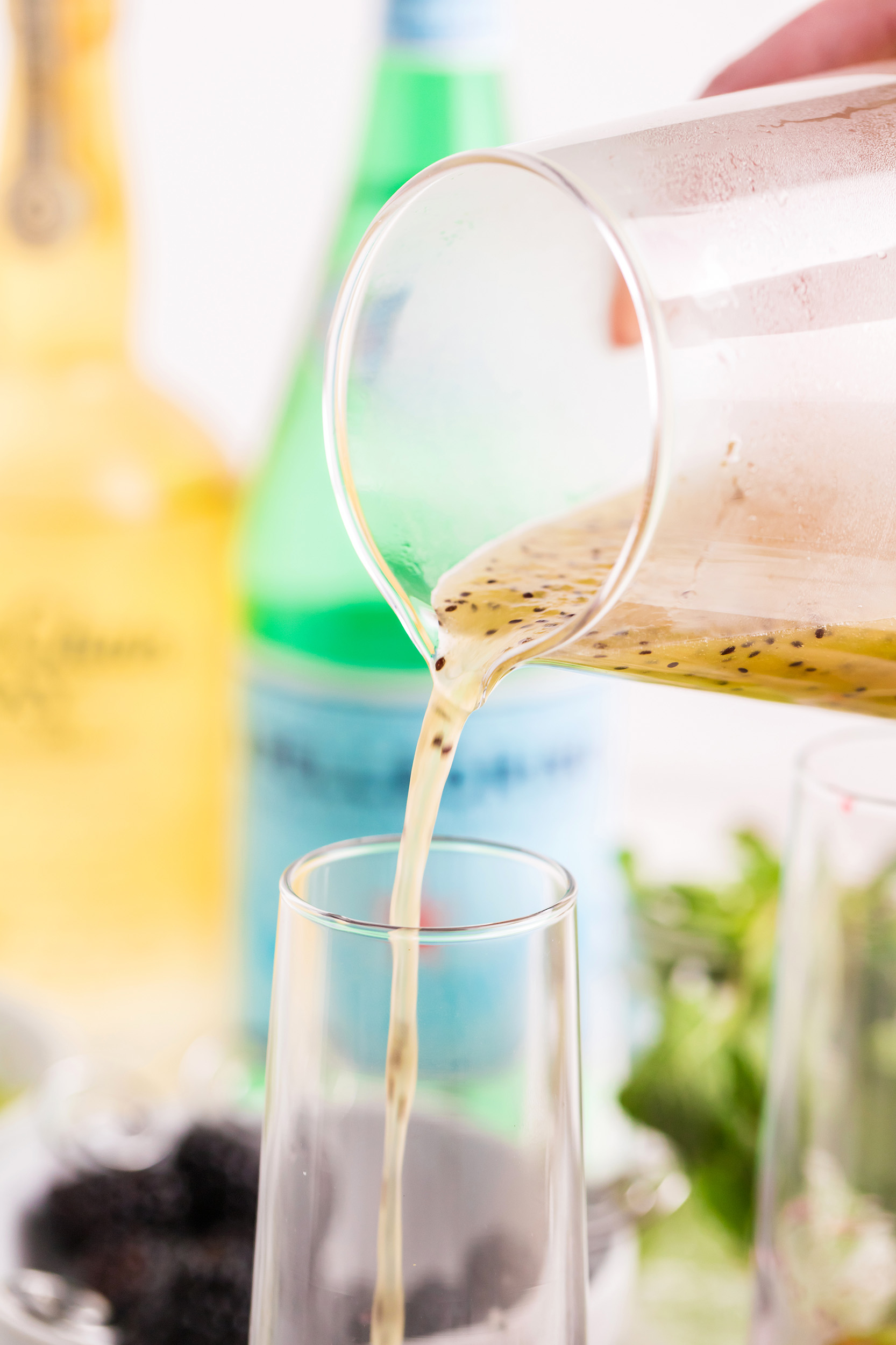 kiwi simply syrup being poured into a tall narrow glass