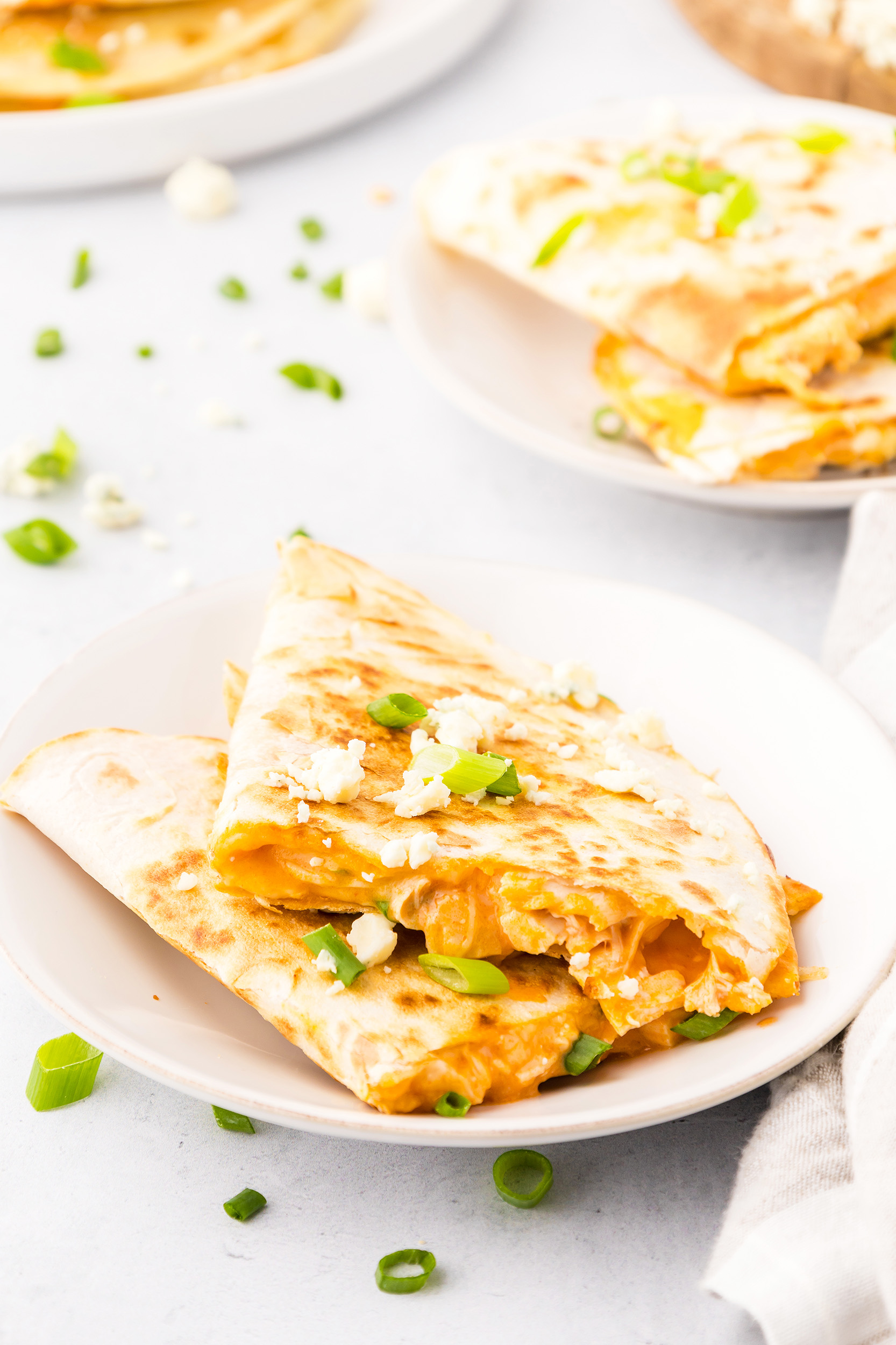 two buffalo chicken quesadilla halves on a small plate