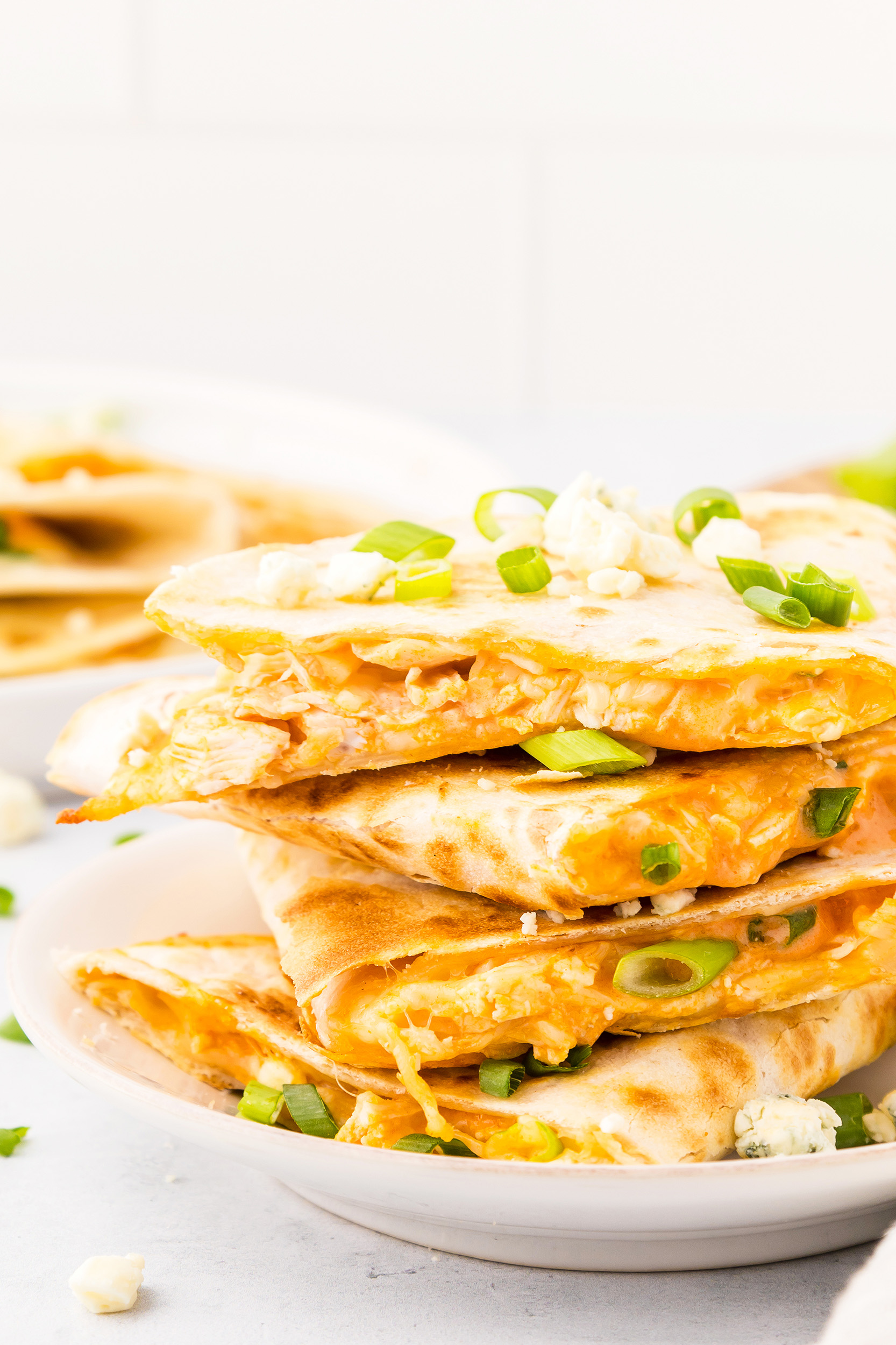 gooey cheese and green onions can be seen inside the buffalo chicken quesadilla