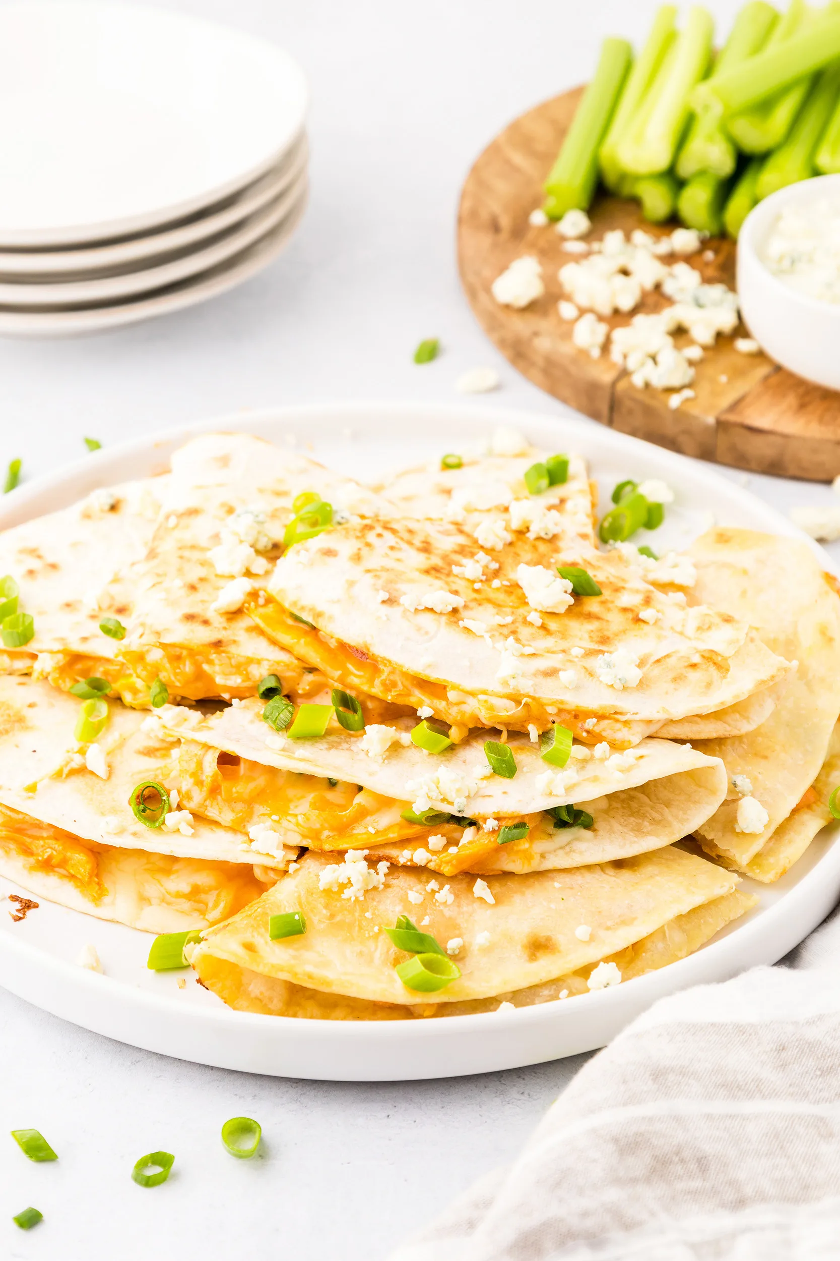 plate of buffalo chicken quesadilla half topped with crumbled blue cheese