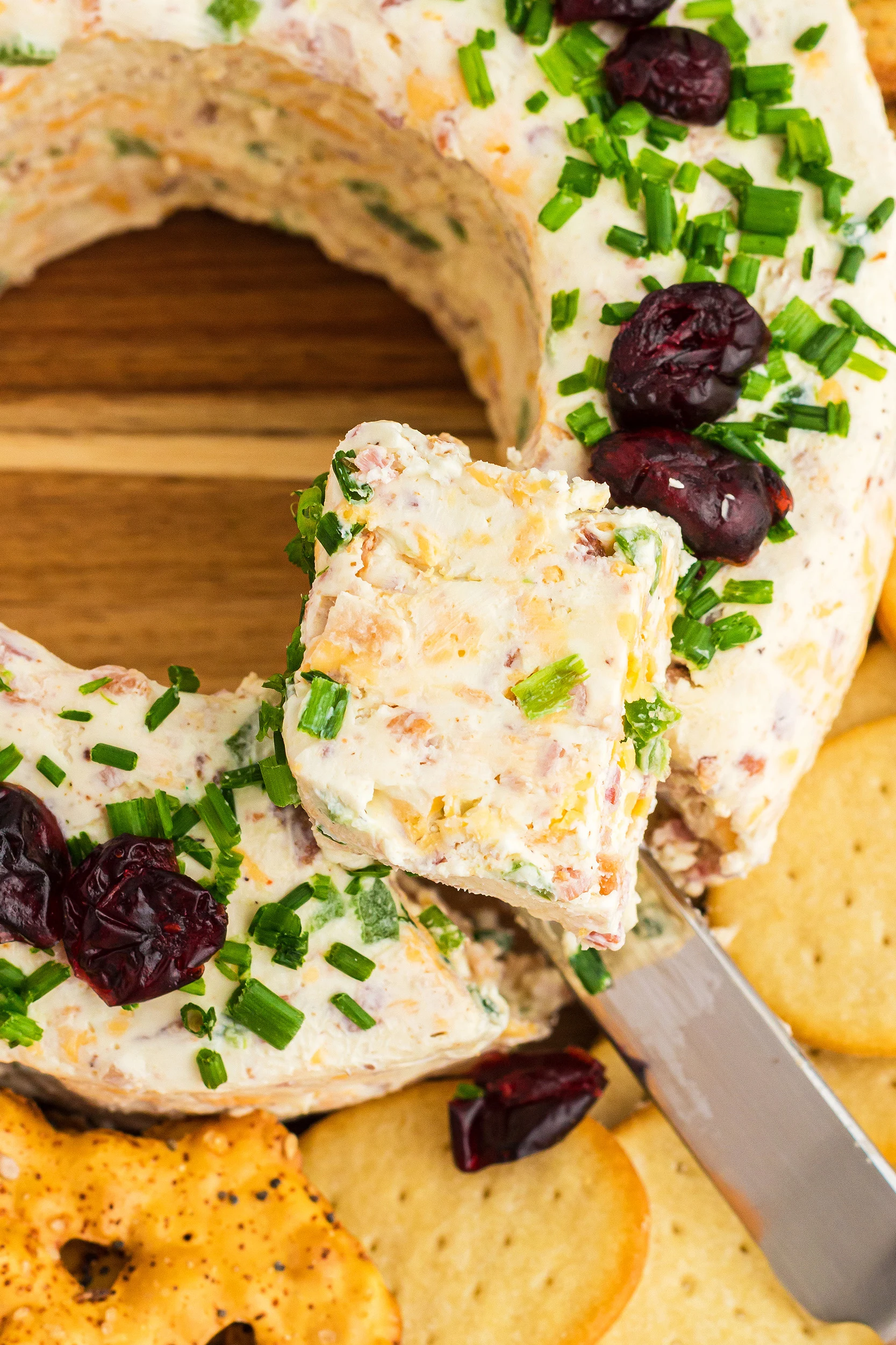 closeup photo of a slice of cheese ball wreath on a butter knife