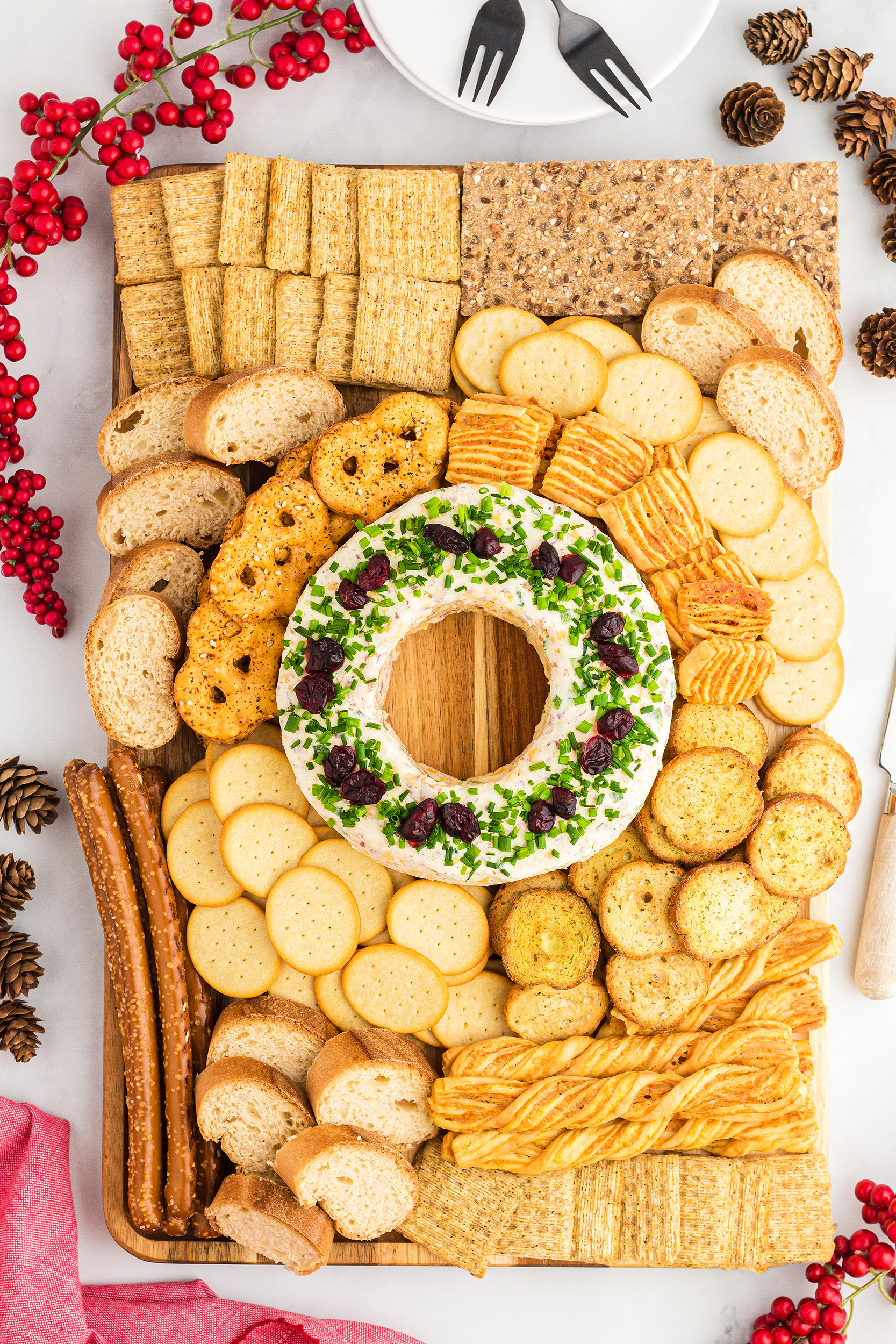 large charcuterie board with a festive Christmas cheese ball in the center surrounded by an assortment of crackers