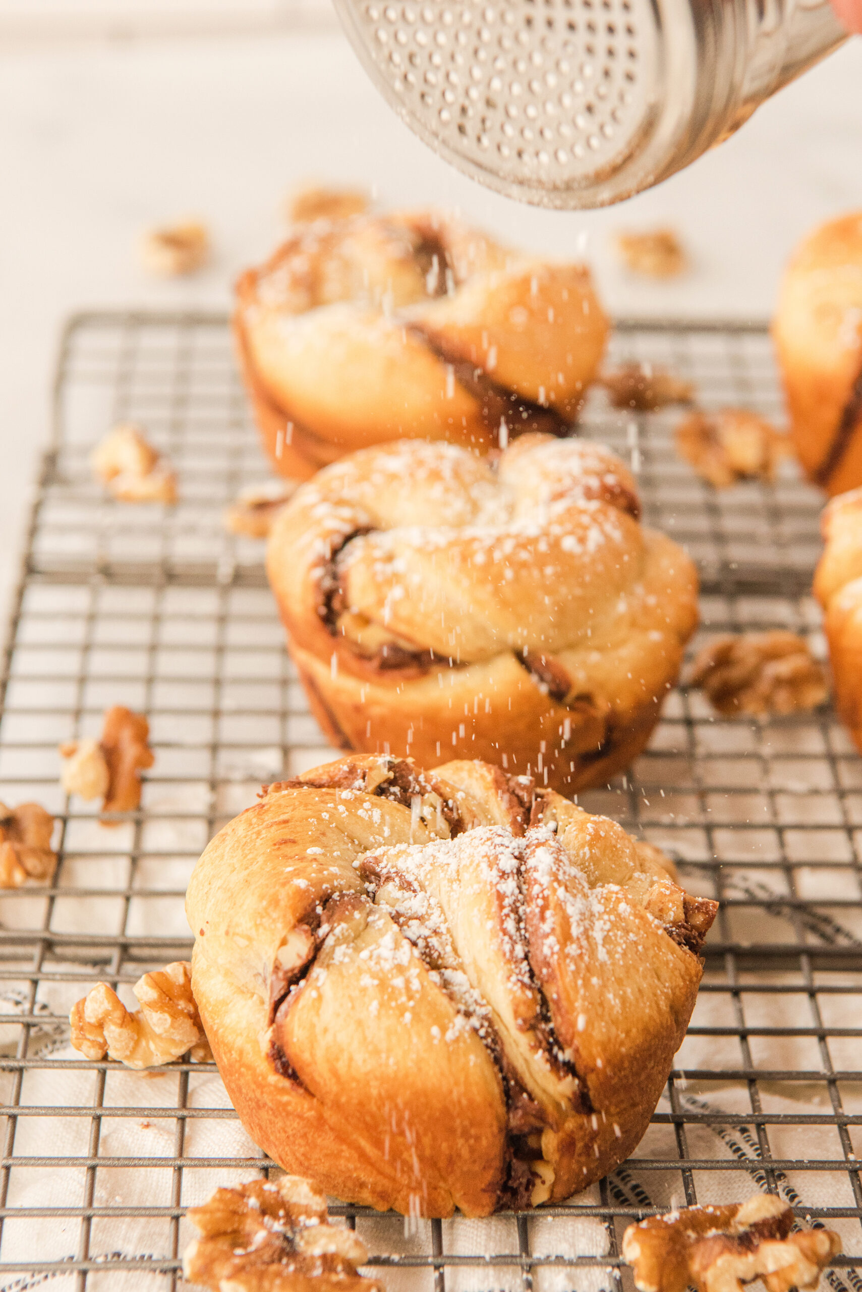 confectioners sugar being sprinkled on top of Nutella muffins