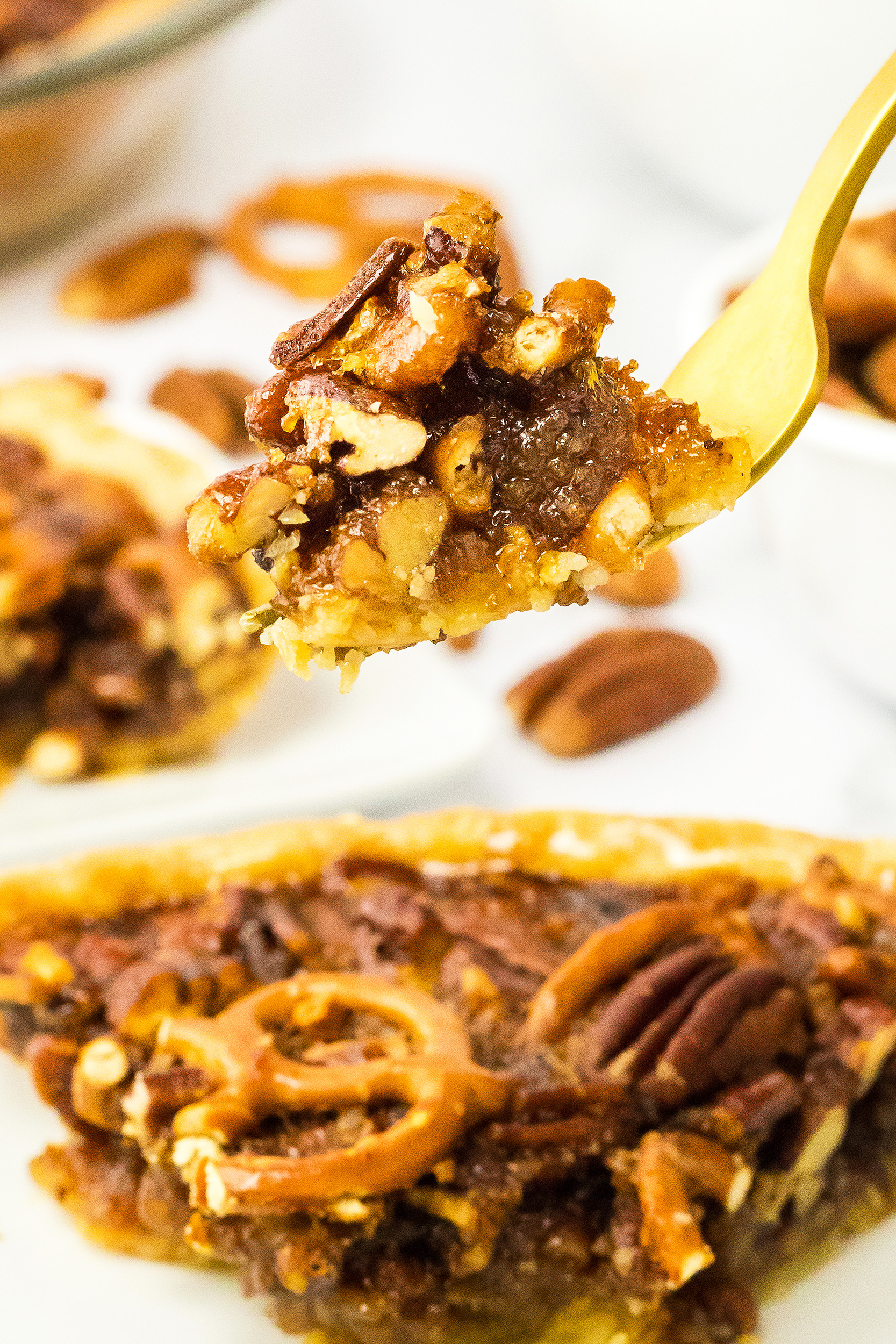 gooey pecan pie on a gold fork