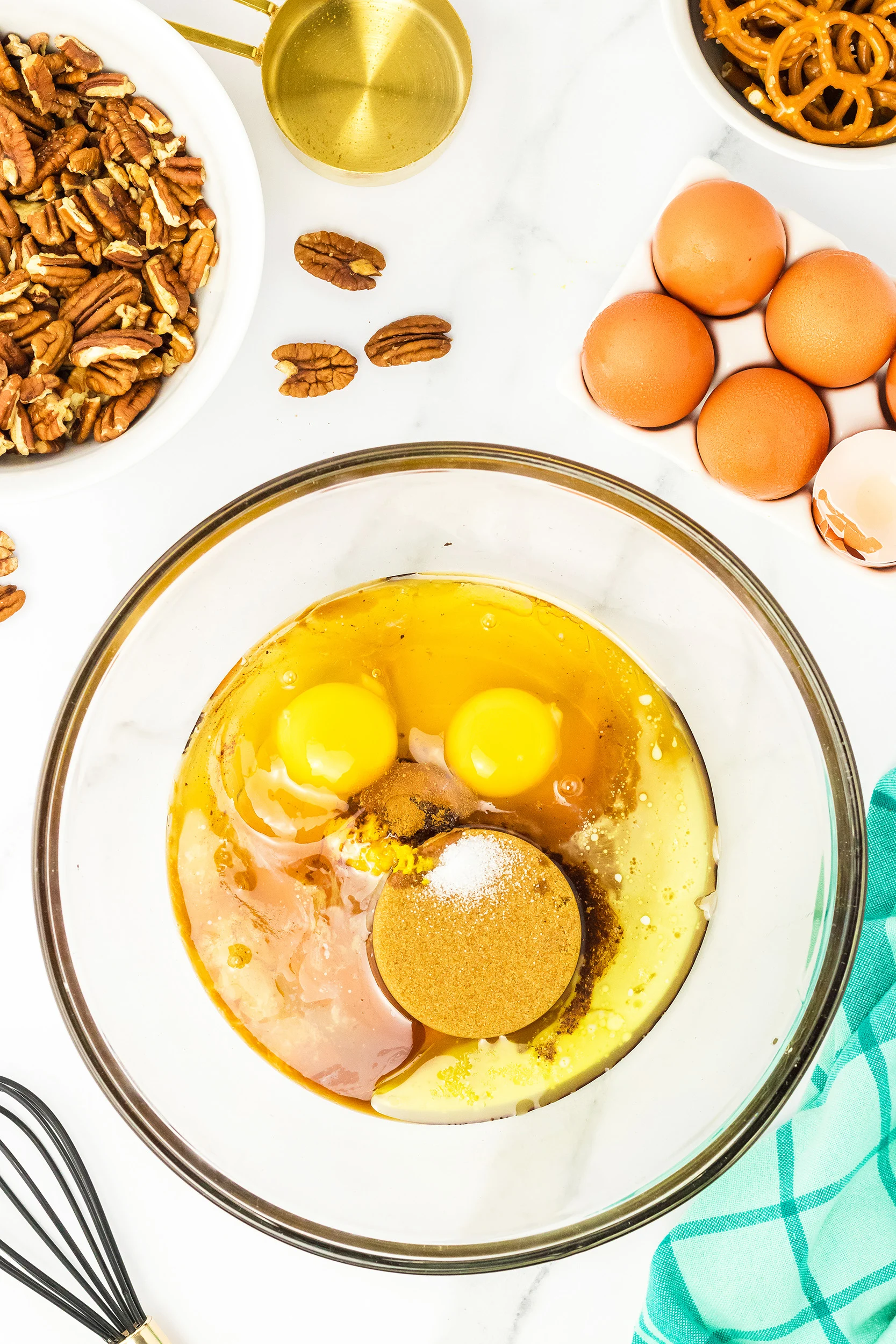 liquid and dry ingredients for pecan pie in a clear medium mixing bowl