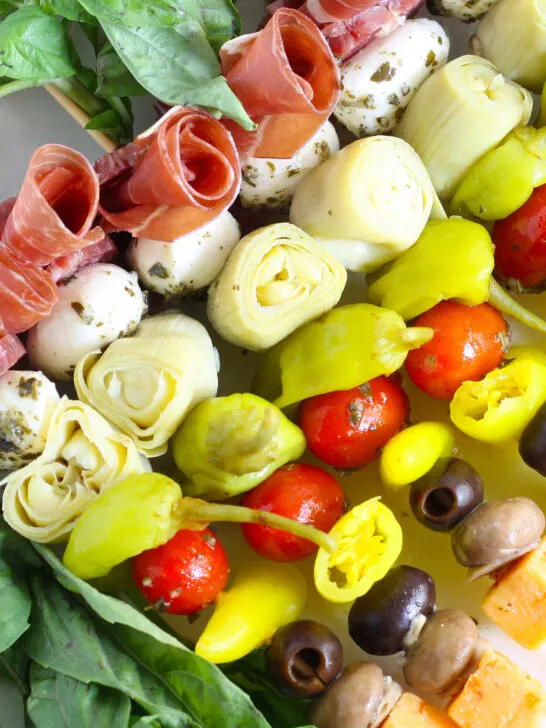 antipasti skewers with marinated ingredients like mushrooms and artichokes, peppers, meat, and cheese
