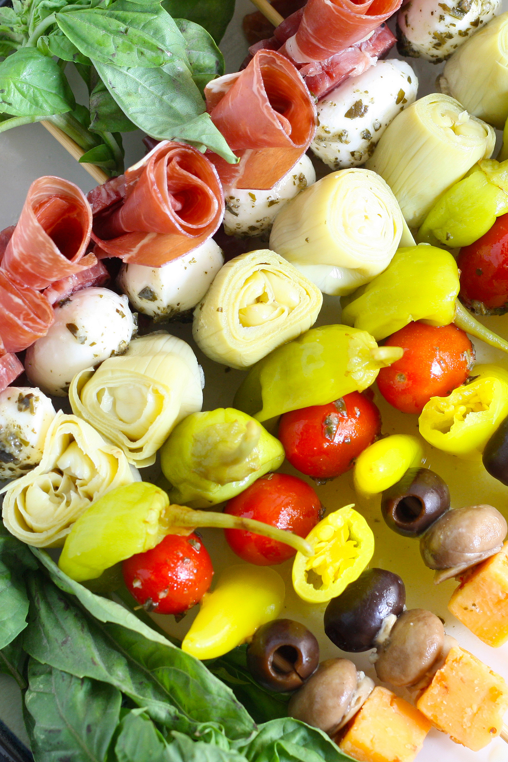 antipasti skewers with marinated ingredients like mushrooms and artichokes, peppers, meat, and cheese