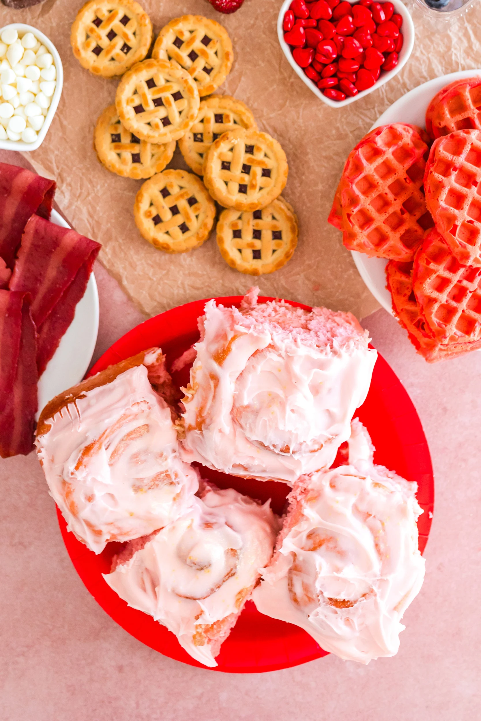 four strawberry cinnamon rolls on a red plate