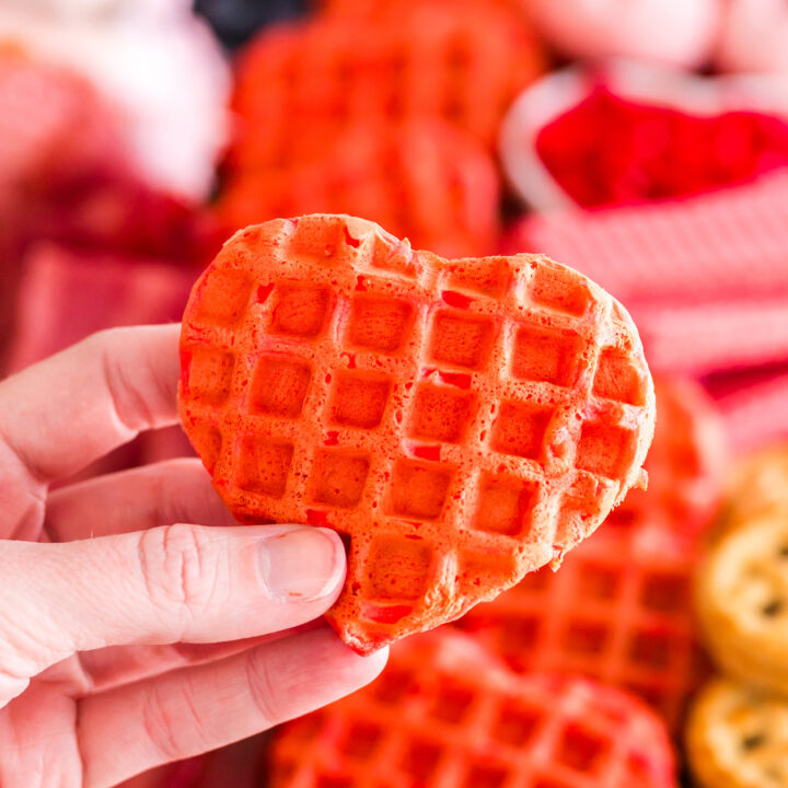 heart shaped strawberry waffle being held by a hand