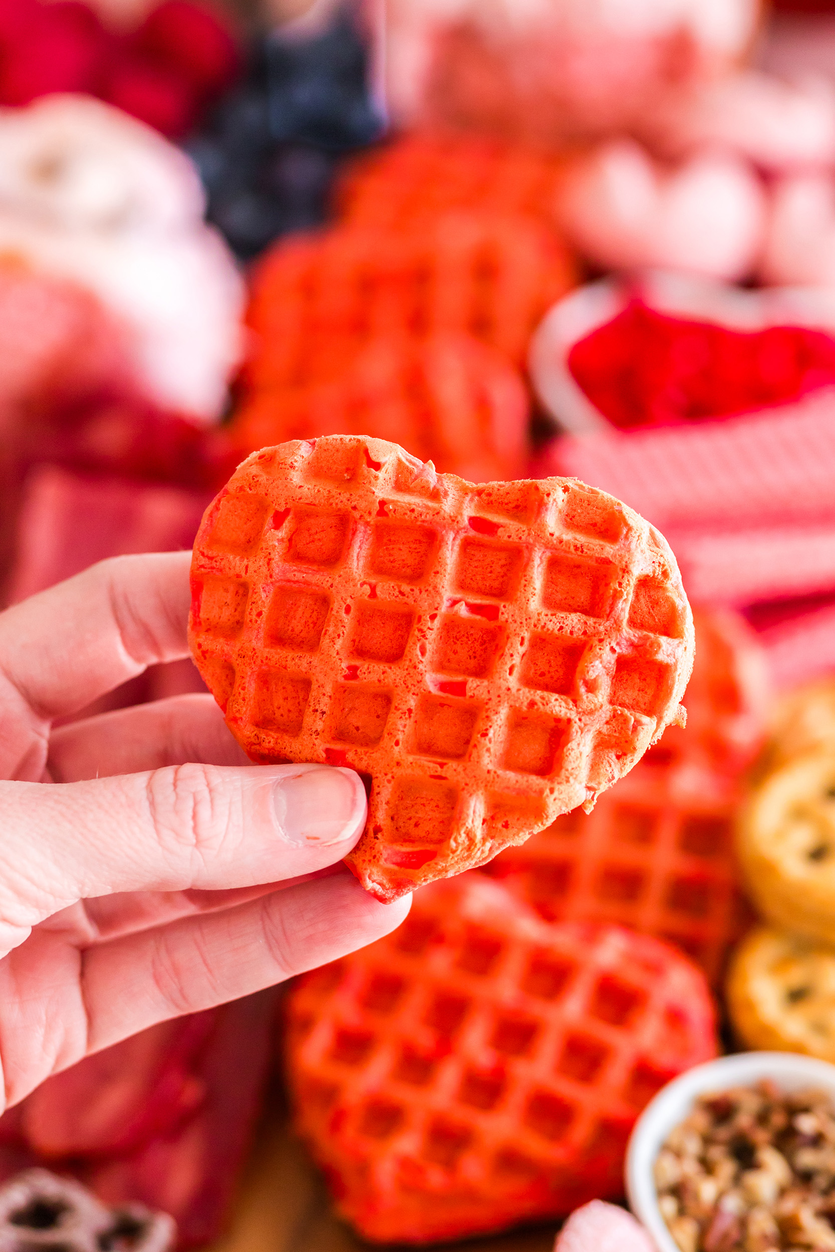 heart shaped strawberry waffle being held by a hand