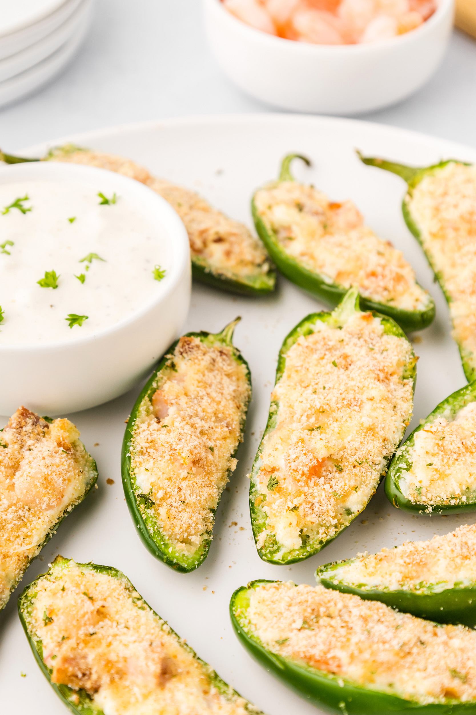 stuffed shrimp jalapeño poppers on a white plate with ranch dressing