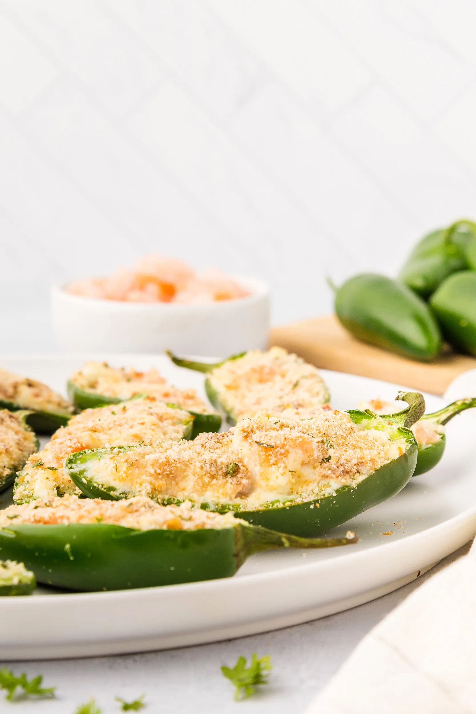 jalapeño poppers with a bowl of cooked shrimp in the background