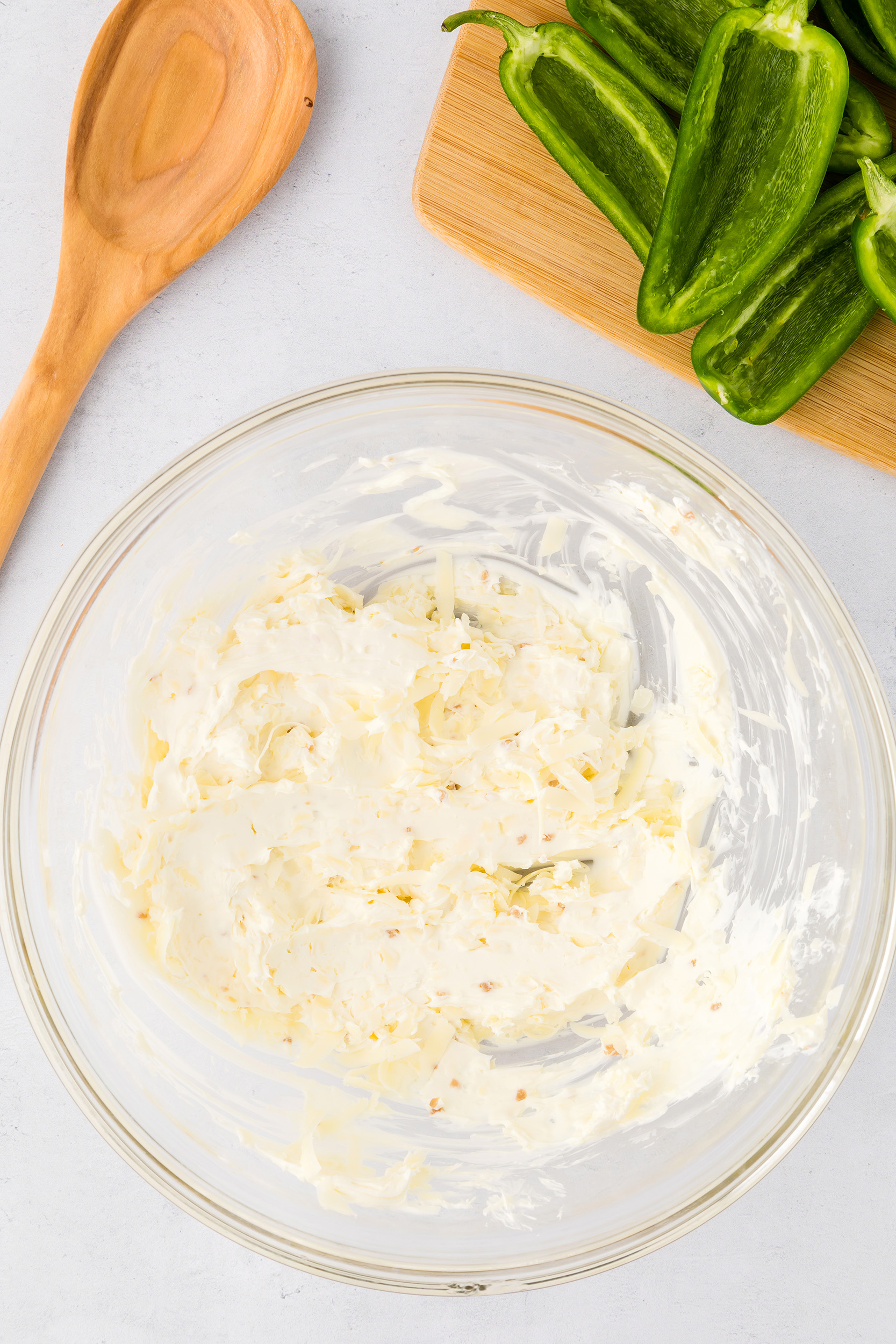 cream cheese and shredded cheese combined in a glass bowl