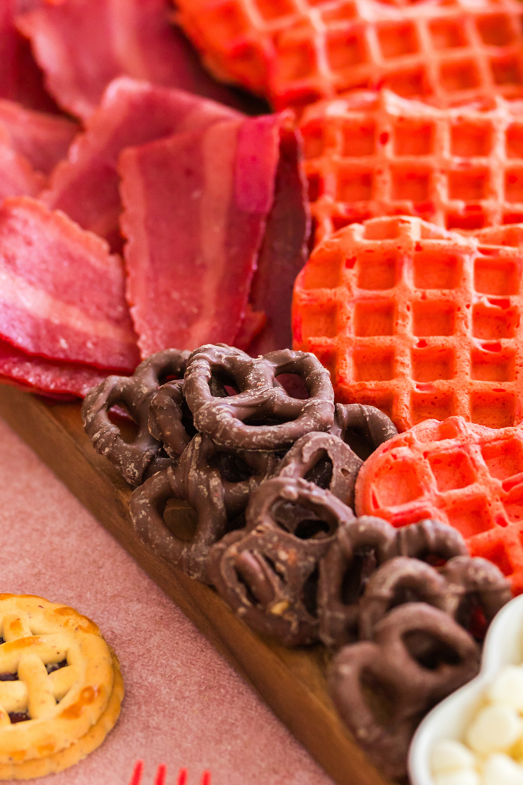 milk chocolate covered strawberries next to heart shaped waffles and heart shaped bacon