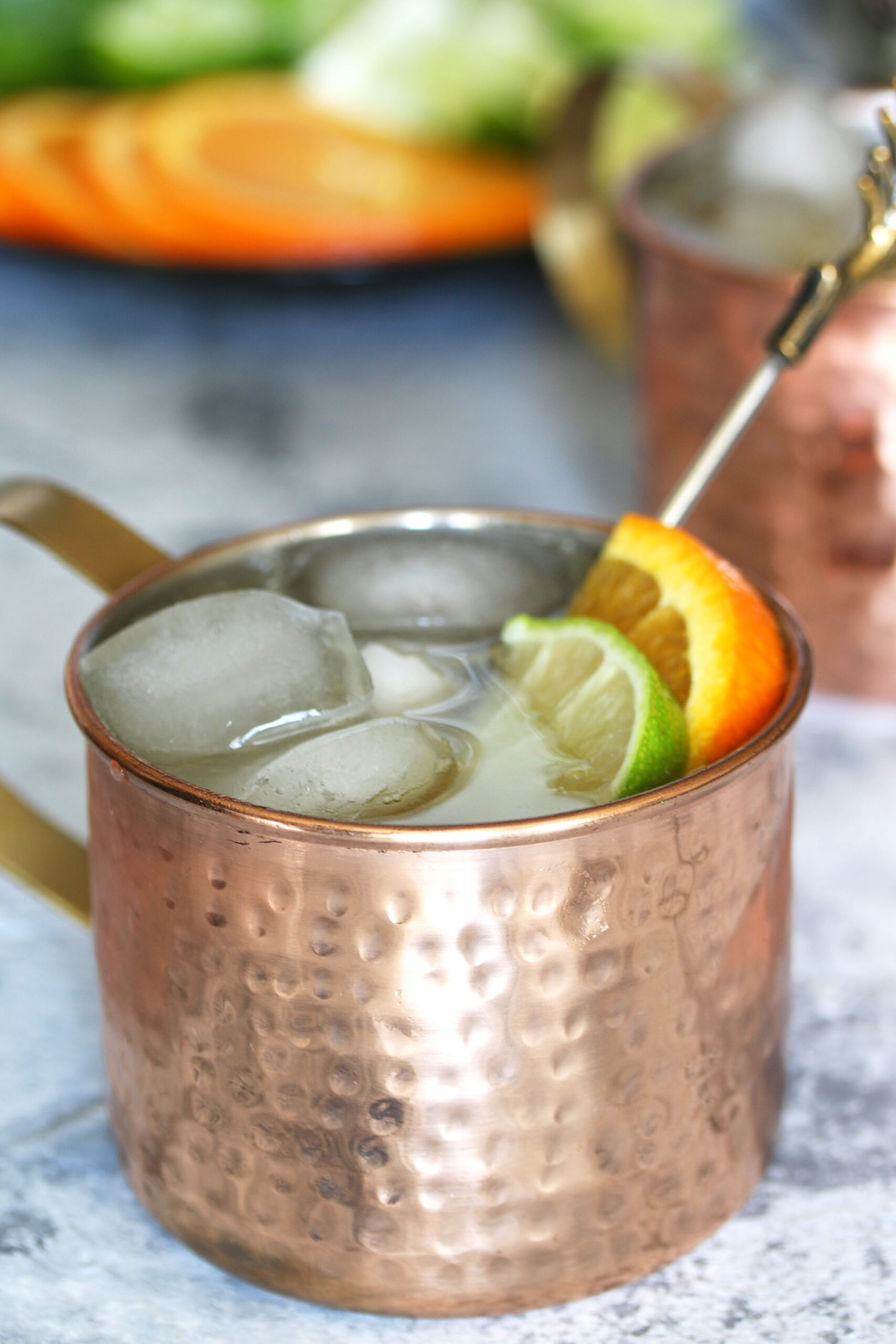 orange Moscow Mule garnished with a lime wedge and an orange slice