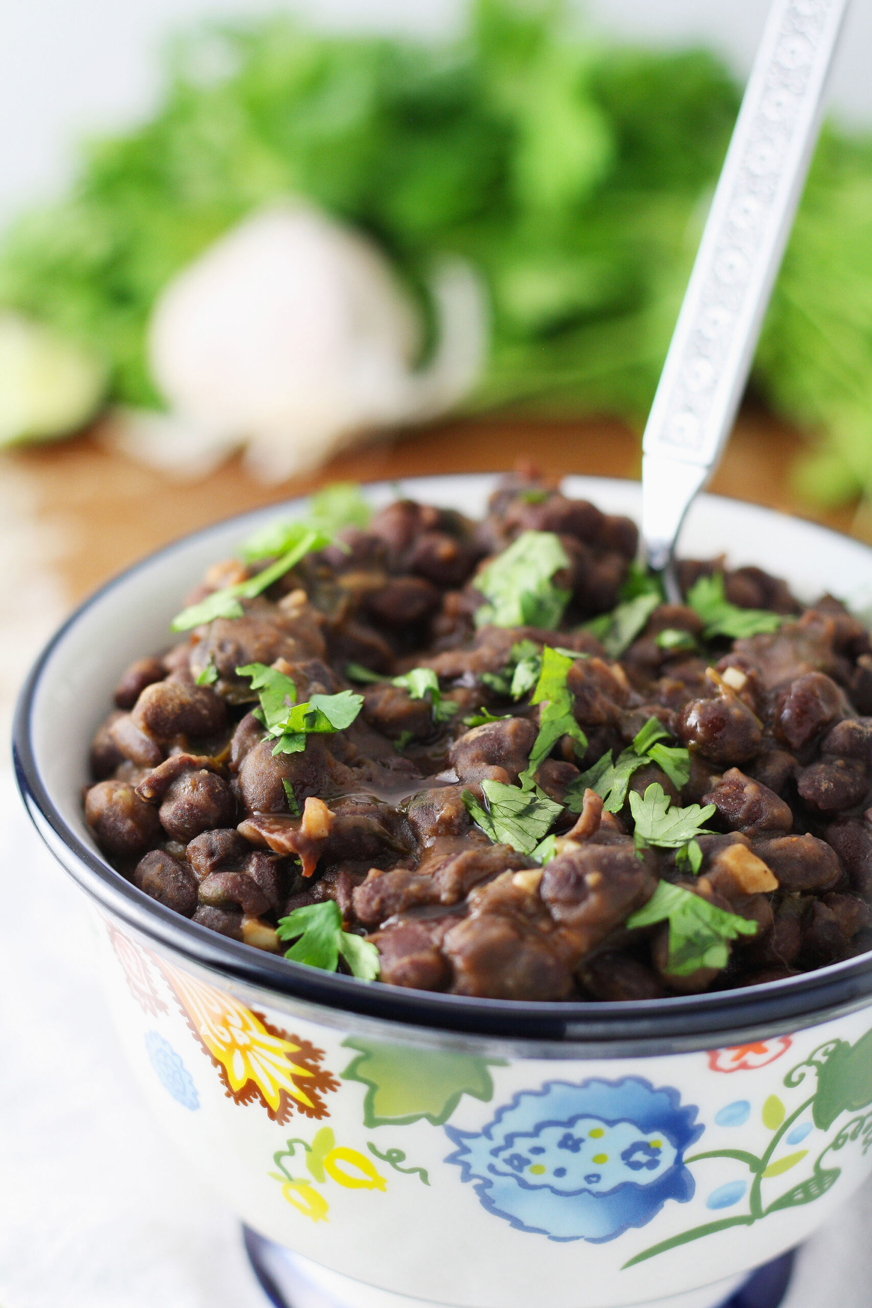 4 servings of seasoned black beans in a bowl with a fork